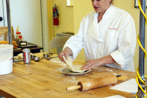 King Arthur Flour employee Robyn places rolled out pie crust into a pie pan. Taken at King Arthur Flour's Baking Education Center.